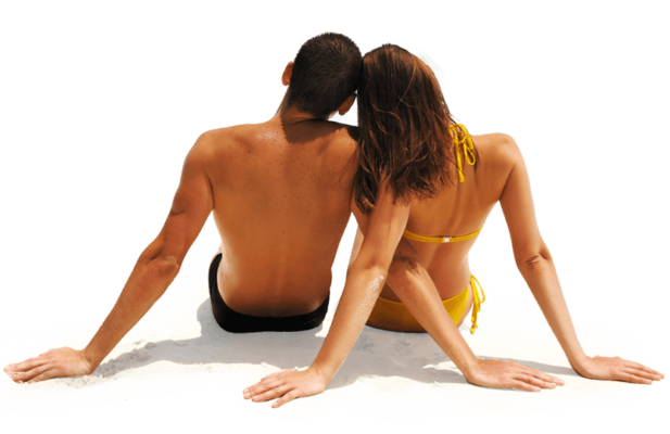 A man and a woman sitting on the sand at the beach